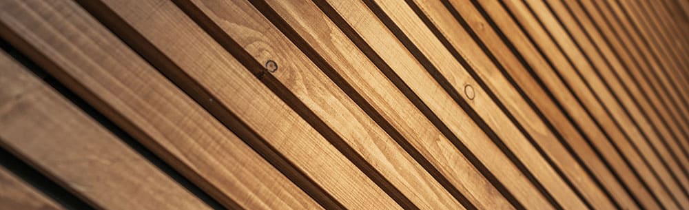 Detail open gevelsysteem met horizontale houten latten en tussenruimte voor ventilatie