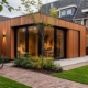 Mantelzorgwoning met warme houtuitstraling, verticale gevelbekleding en eigentijdse architectuur in Nederlandse woonwijk.